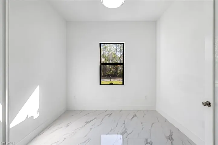 Empty room featuring light marble finish floors and baseboards