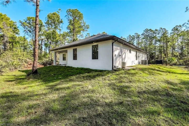 View of home's exterior with a lawn and stucco siding