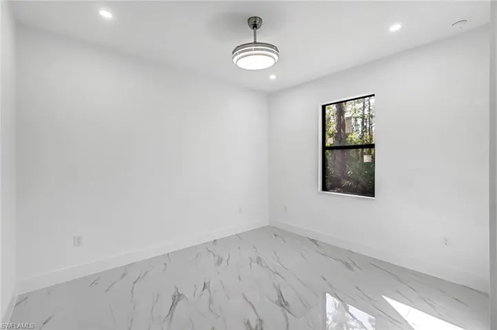 Unfurnished room featuring marble look tile flooring and recessed lighting