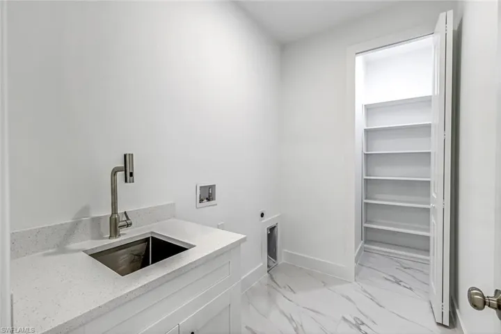 Laundry area with light marble finish flooring, hookup for an electric dryer, and hookup for a washing machine