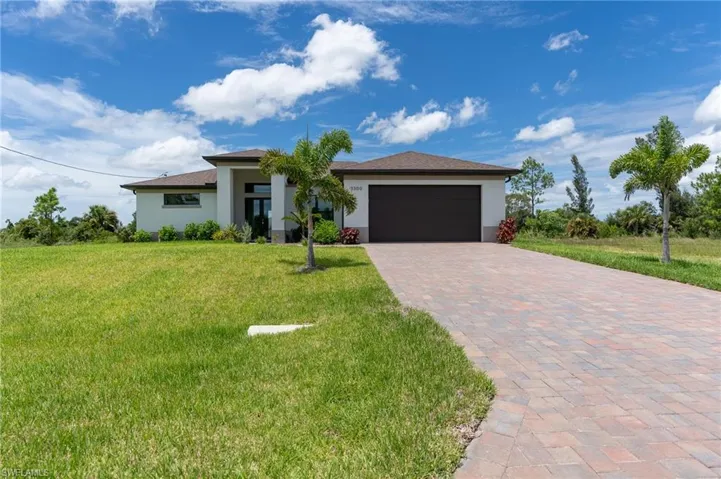 View of front of home featuring a garage and a front lawn