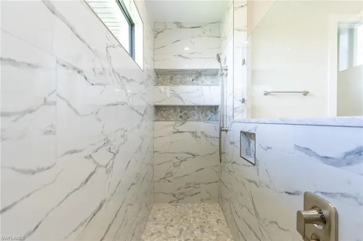 Bathroom featuring rain shower, hand held shower, and niches