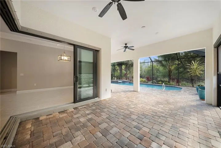 View of patio / terrace featuring a pool with connected hot tub, a ceiling fan, a lanai, and a sunroom