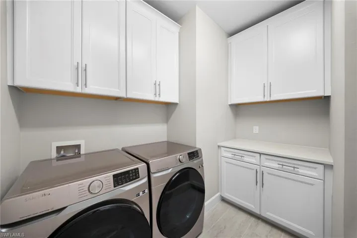 Laundry room with independent washer and dryer and cabinet space