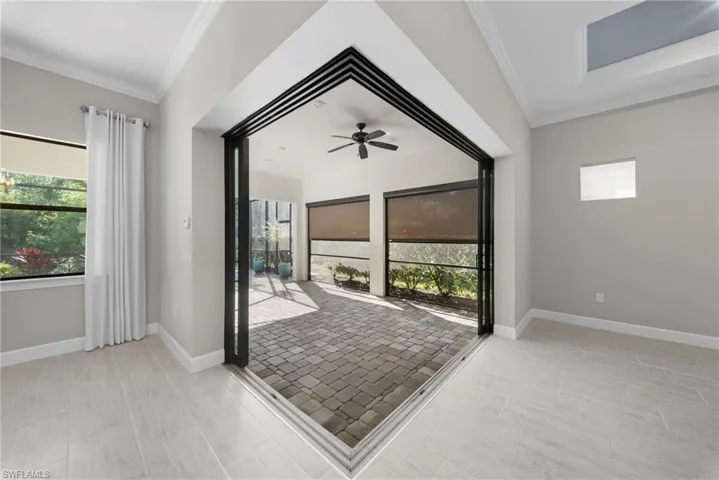 Empty room with ornamental molding, ceiling fan, and healthy amount of natural light