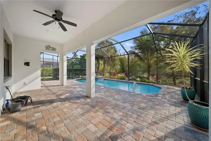 Outdoor pool with a patio, a sunroom, and a lanai