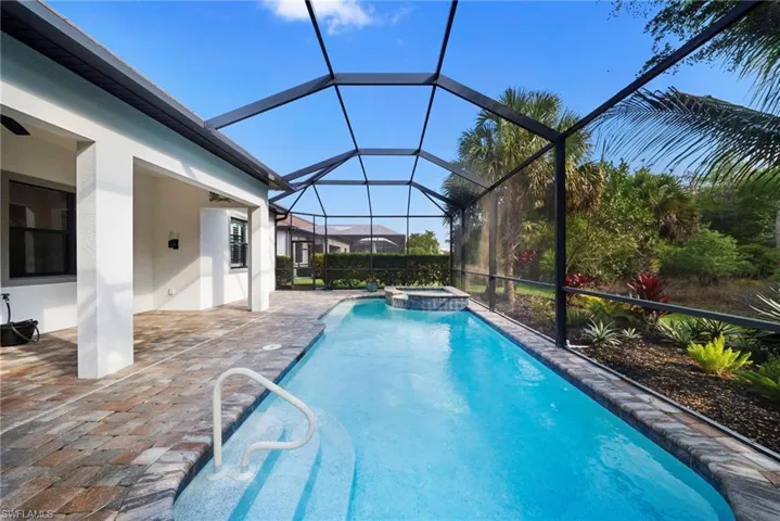Integrated pool / hot tub with a patio, a sunroom, and a lanai