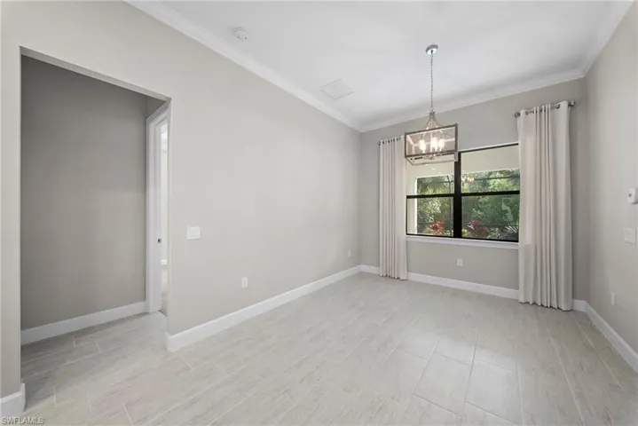 Spare room featuring crown molding and hanging lights