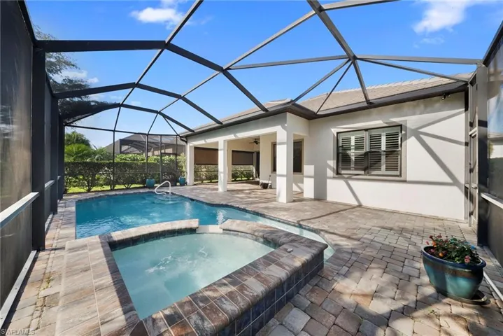 Combined pool / hot tub featuring a sunroom, a patio, and a lanai