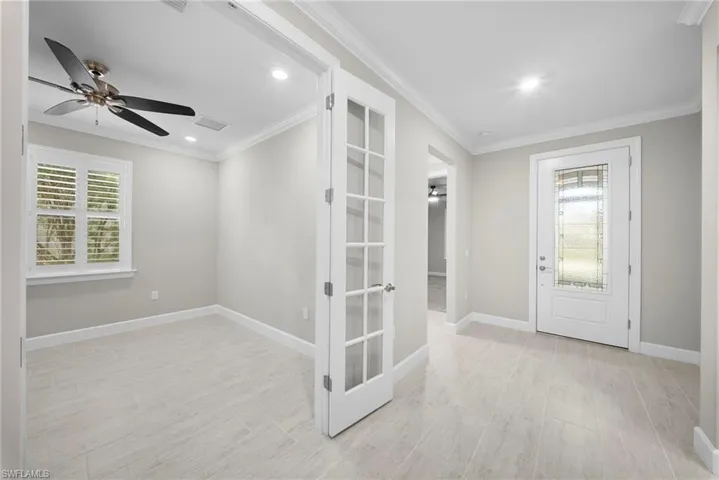 Entryway with a ceiling fan, ornamental molding, and recessed lighting