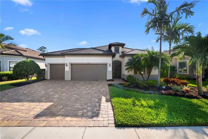Prairie-style home with decorative driveway, a garage, stucco siding, a front yard, and a tile roof