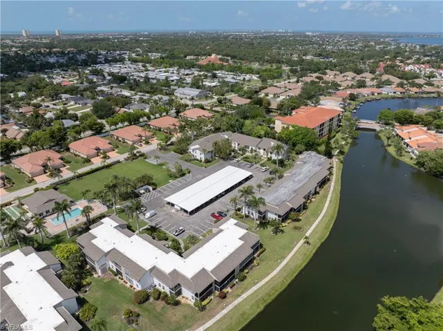 Aerial view of property and surrounding area featuring a nearby body of water and nearby suburban area