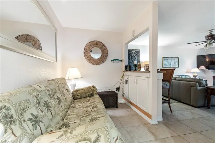 Living room with a ceiling fan and light tile patterned floors