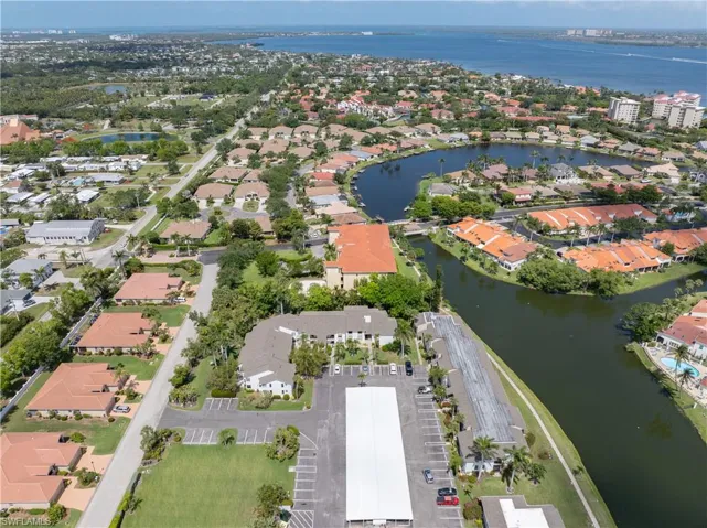 Aerial view of property and surrounding area featuring a large body of water and nearby suburban area