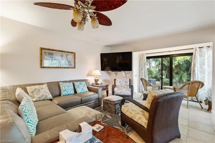 Living area with ceiling fan and light tile patterned flooring