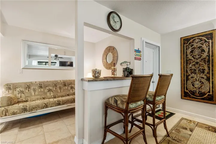 Bar area with tile patterned flooring, a ceiling fan, and baseboards