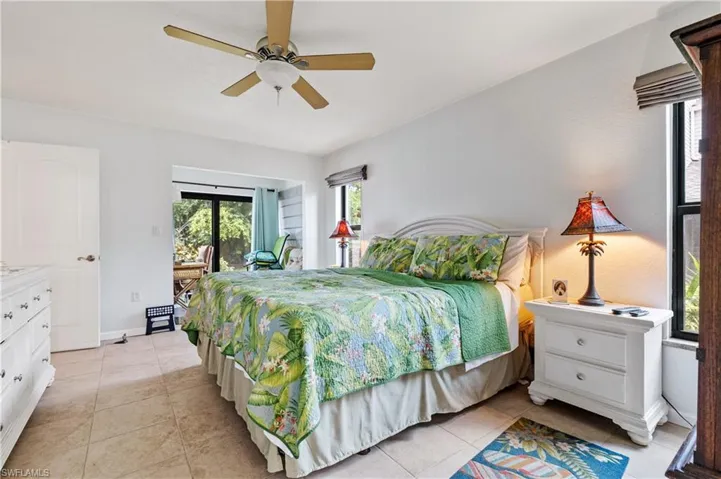 Bedroom featuring access to outside, light tile patterned flooring, ceiling fan, and baseboards