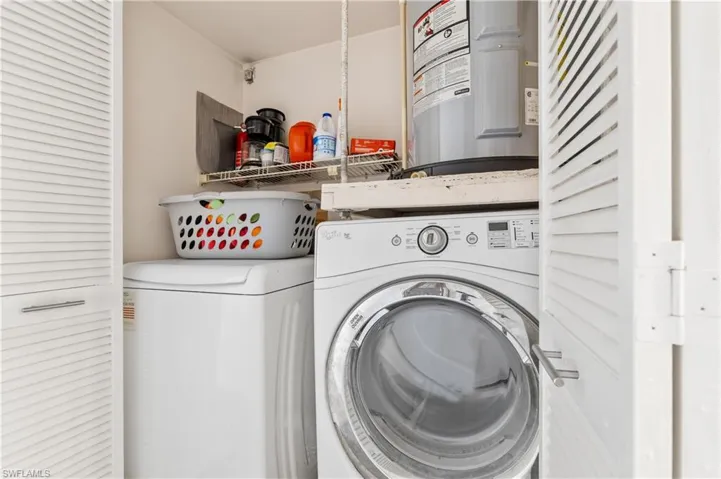 Washroom featuring washer and clothes dryer and electric water heater