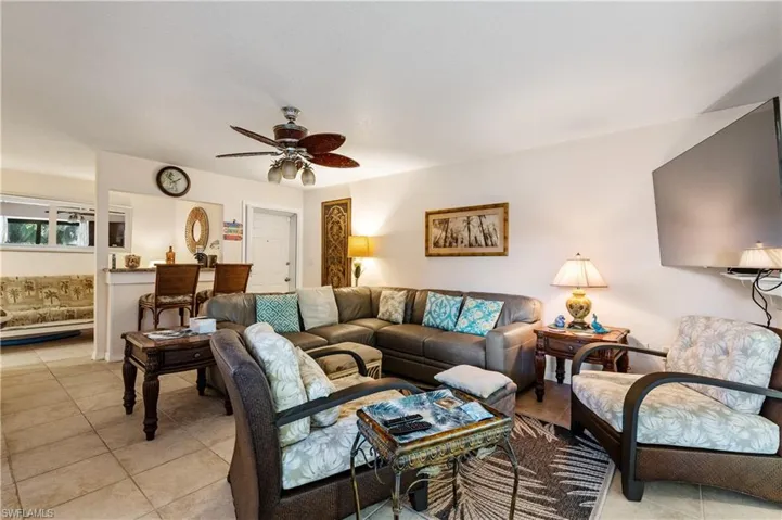 Living area with ceiling fan and light tile patterned flooring