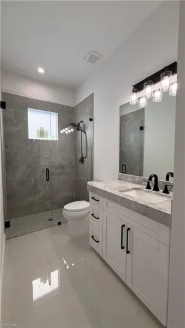 Full bathroom featuring a shower stall and vanity