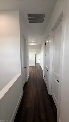 Hallway featuring dark wood-type flooring and recessed lighting
