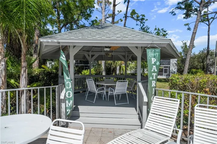 Raised gazebo with a gabled roof featuring a ceiling fan, composite decking, and open railings