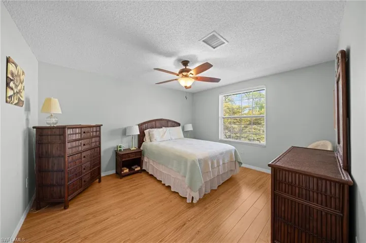 Spacious room featuring wood-finish flooring and light-toned walls