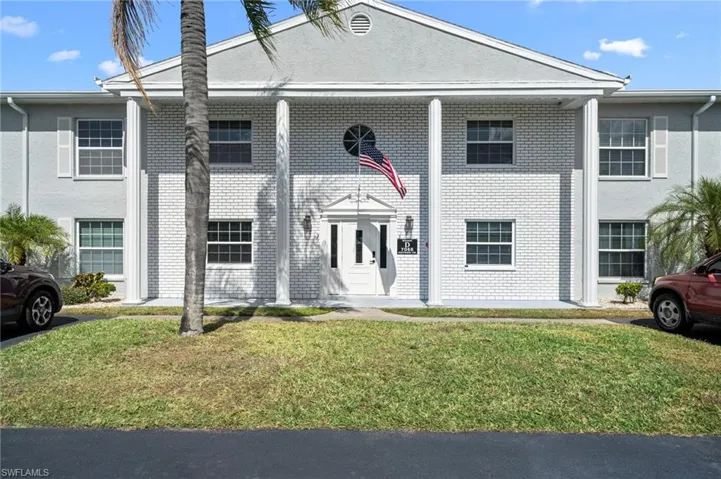 Two-story facade with a central white brick section and light gray stucco wings
