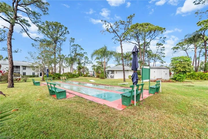 Shuffleboard courts surrounded by mature trees, featuring dedicated seating areas