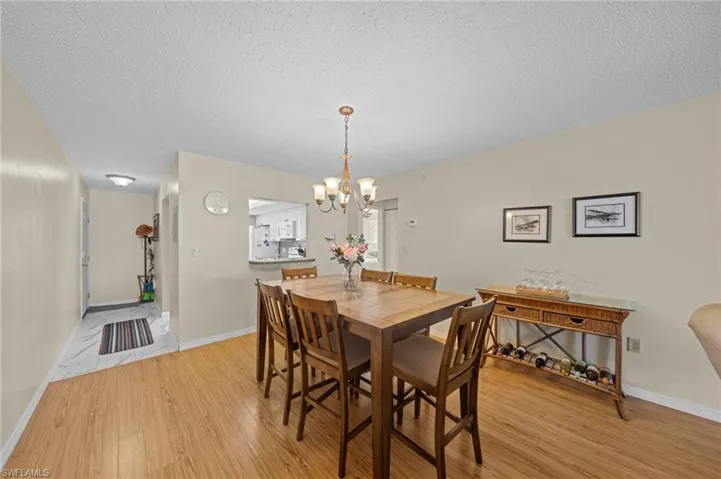 Dining area featuring wood-finish flooring and a central chandelier