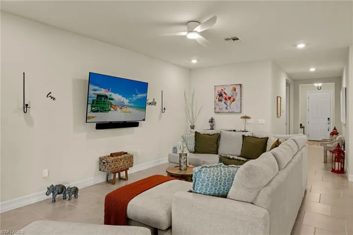 Living room with light tile patterned floors and ceiling fan