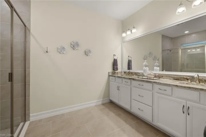 Bathroom featuring an enclosed shower, tile patterned floors, and vanity