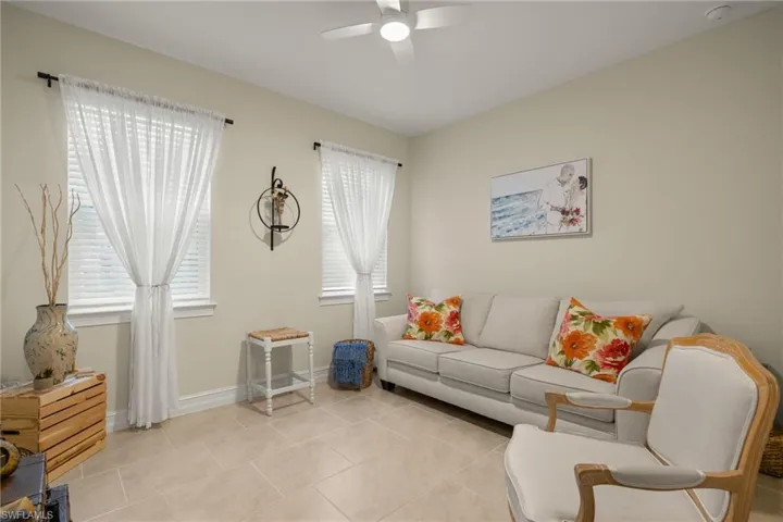 Living room with light tile patterned floors and ceiling fan