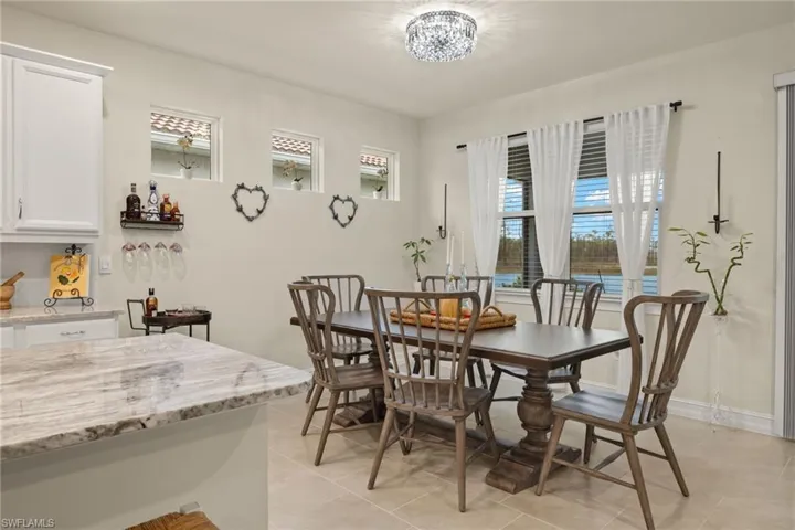 Dining space featuring light tile patterned floors and an inviting chandelier