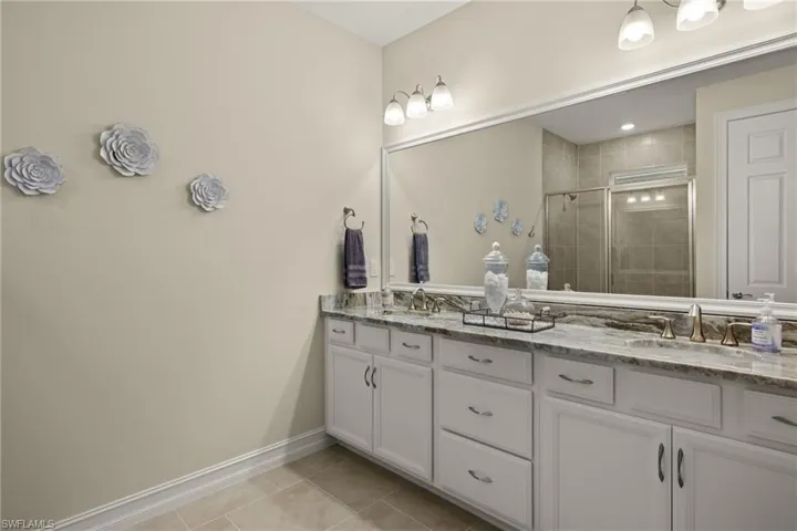 Bathroom featuring tile patterned floors, walk in shower, and vanity