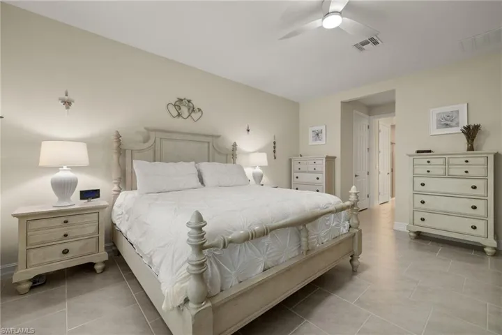 Tiled bedroom featuring ceiling fan