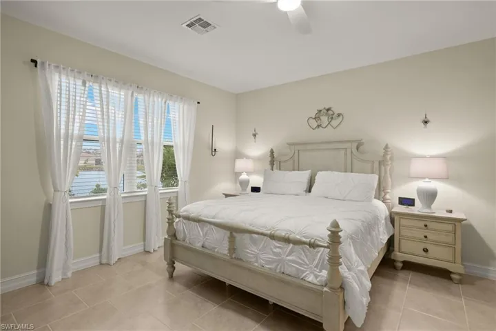 Tiled bedroom featuring ceiling fan