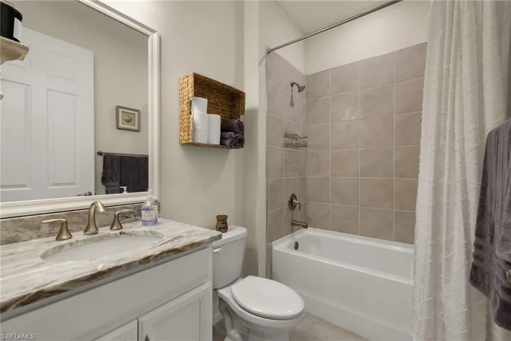 Full bathroom with vanity, toilet, and shower / bath combo with shower curtain
