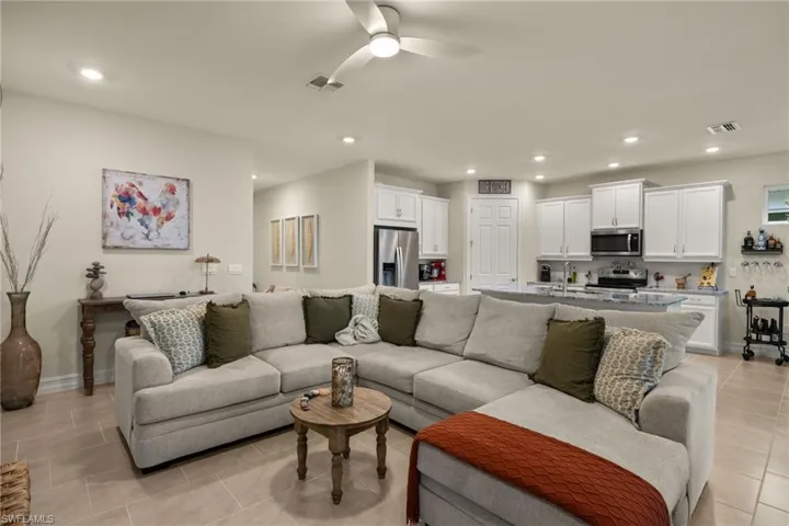 Living room with sink, light tile patterned flooring, and ceiling fan