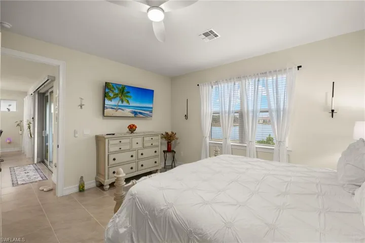 Tiled bedroom featuring ceiling fan
