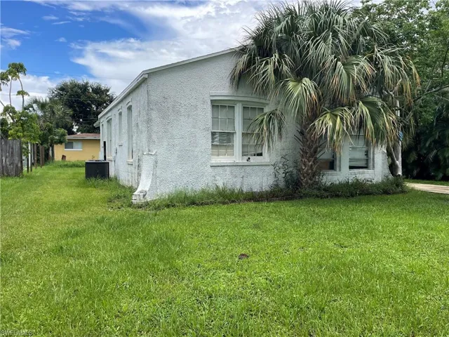 White stucco exterior with a prominent palm tree