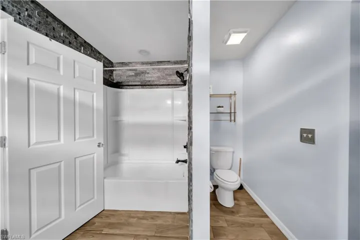 Bathroom featuring light wood-type flooring and shower / bathtub combination
