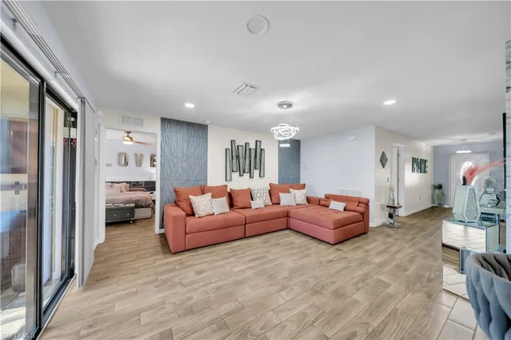 Living room with light wood-style flooring, ceiling fan, and recessed lighting