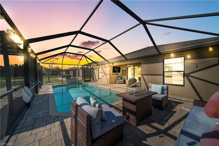 Outdoor pool featuring an outdoor living space, a sunroom, a patio, and a lanai