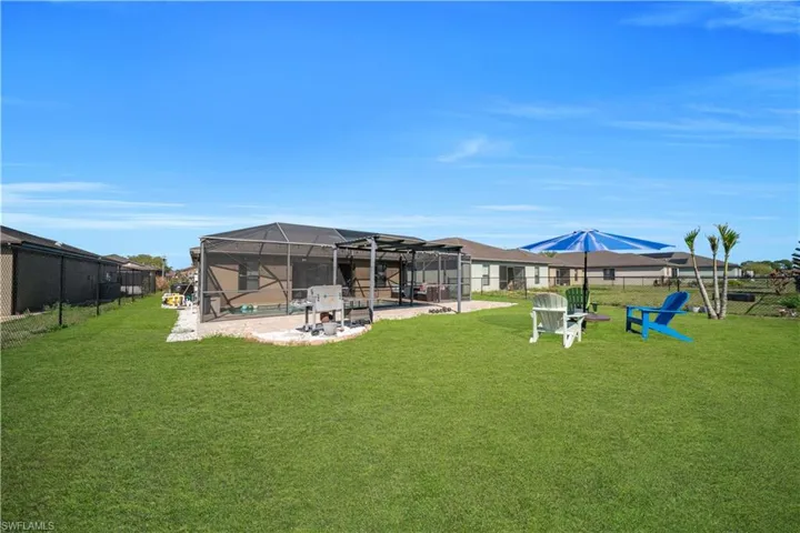 Fenced backyard with a sunroom, a patio area, a swimming pool, and a lanai