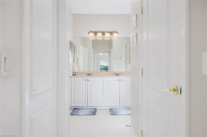Full bathroom featuring light tile patterned floors and double vanity