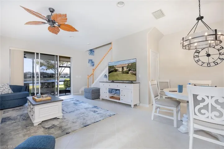 Living room featuring ceiling fan, suspended lighting, and light tile patterned flooring