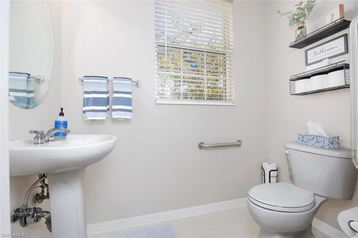 Half bathroom featuring toilet and light tile patterned flooring