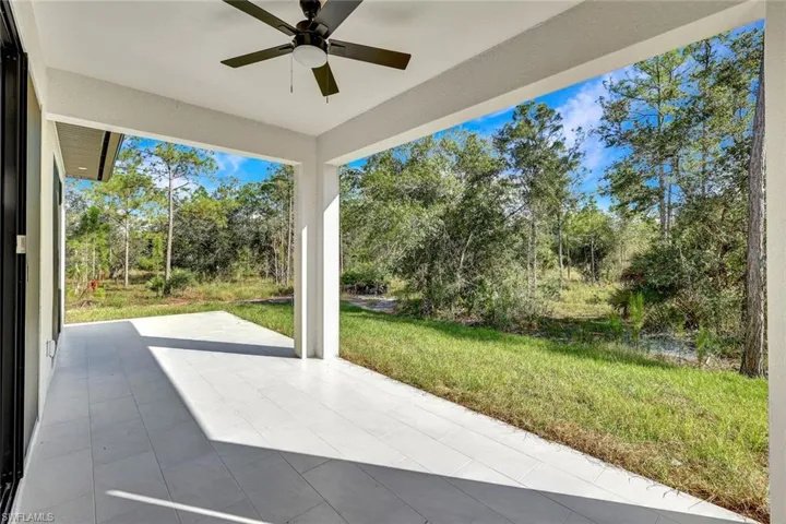 View of patio / terrace with a ceiling fan and view of wooded area