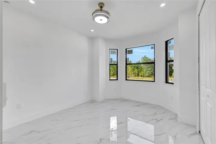 Unfurnished room featuring recessed lighting and light marble finish floors